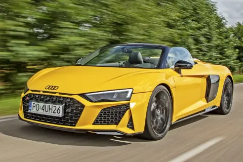 Żółte Audi R8 Spyder w ruchu. Sprawdź aktualną audi r8 cena i poczuj wolność na drodze.