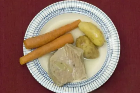 Ein deftiges Gericht: zarte Karotten, Kartoffeln und ein Stück Fleisch, das an Kuheuter erinnert, schwimmen in einer Brühe.