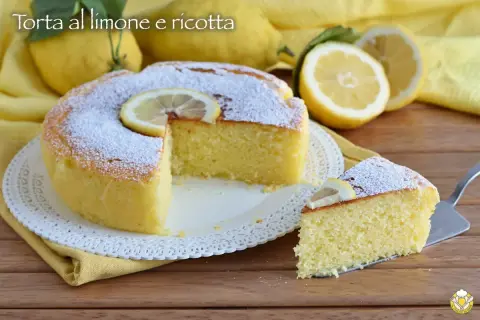 Torta soffice alla ricotta e limone, spolverata di zucchero a velo e decorata con una fetta di limone.