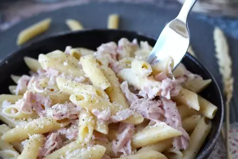 Penne cremose con prosciutto cotto e parmigiano, un piatto semplice e gustoso.