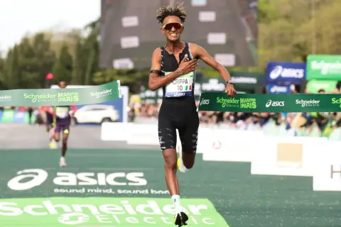 Crippa taglia il traguardo della maratona di Parigi, esausto ma vittorioso. La sua corsa è un'ispirazione.