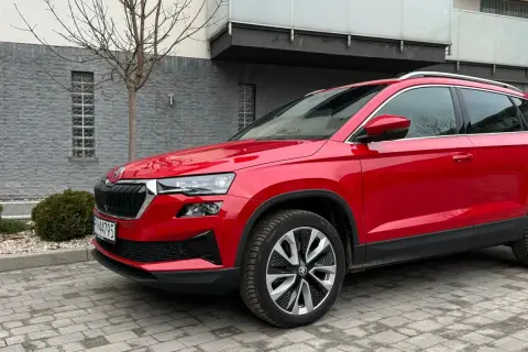 Czerwona Skoda Karoq na tle nowoczesnego budynku. Wiele osób szuka skoda karoq opinie, by podjąć decyzję o zakupie.
