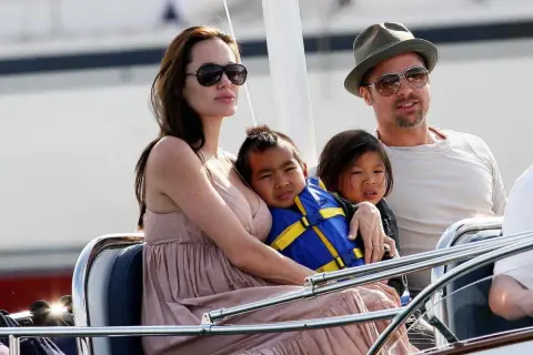 Angelina Jolie med sina barn på en båt. En av barnen bär en blå flytväst.