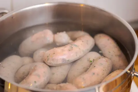 Kiełbasa gotuje się w garnku. Dowiedz się, ile parzyć kiełbasę, by była idealna.