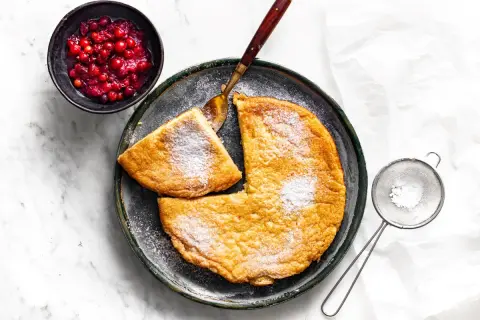 Puszysty omlet, posypany cukrem pudrem, z żurawiną obok. Idealny przepis na pyszne śniadanie.
