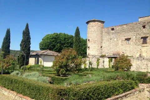 Giardino all'italiana con torre medievale, un luogo dove i sogni del Chianti prendono vita tra siepi curate e profumi di lavanda.