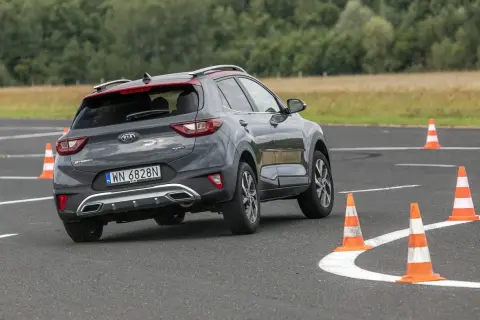Szary Kia Stonic na torze z pachołkami, ćwiczący podsterowność.