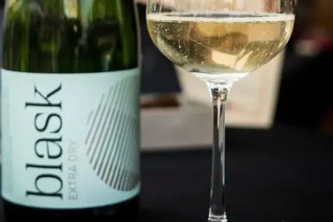 Butelka i kieliszek musującego wina. To jest prosecco, idealne na każdą okazję.