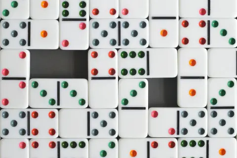 Klocki domino z kolorowymi kropkami, gotowe do gry. Poznaj zasady gry w domino i zacznij zabawę!