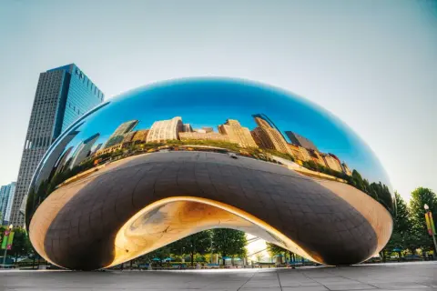 Lśniące dzieła Anish Kapoor odbijają panoramę miasta.