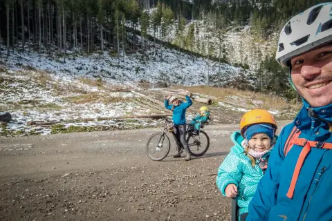 Rodzina na rowerach odkrywa tatrzańskie trasy rowerowe. Radosne dzieci i rodzice cieszą się zimowym krajobrazem.