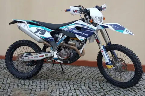 Husqvarna 250 FE z numerem 79, gotowy do akcji na wyboistym terenie.