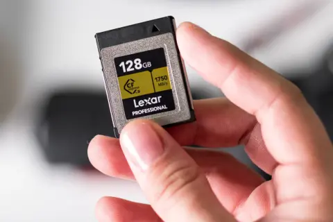 Dłoń trzyma kartę pamięci Lexar 128GB CFexpress B, gotową do włożenia do telefonu lub aparatu.