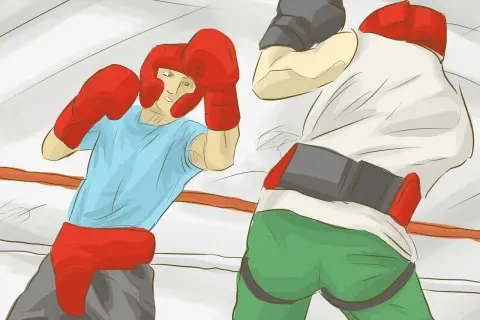 Two boxers in a ring, one in a blue shirt and red headgear, the other in a white shirt and grey cap, demonstrating how to box.