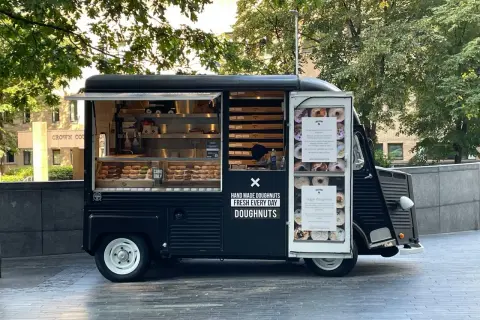 Food truck nero con ciambelle fatte a mano, fresche ogni giorno.