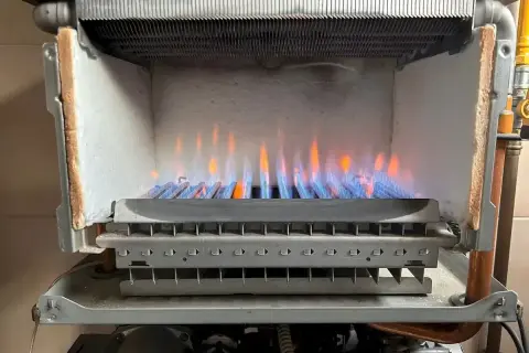 Płomienie palnika w kotle gazowym. Wnętrze kotła, widoczne elementy grzewcze. Dobry wybór dla producentów kotłów gazowych.