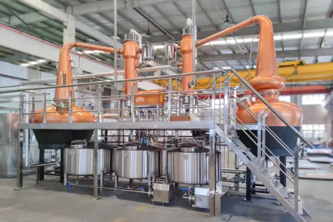 Nowoczesna instalacja do rektyfikacji z miedzianymi alembikami i stalowymi zbiornikami, gotowa do produkcji wysokiej jakości alkoholi.