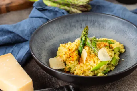 Cremiges Risotto mit frischem Spargel und Parmesan, garniert mit Paprikapulver. Ein Genuss für alle Sinne!