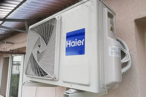 Jednostka zewnętrzna klimatyzatora Haier zamontowana na ścianie budynku.