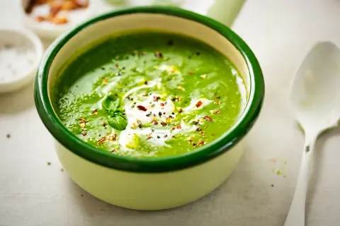 Aksamitna zupa szpinakowa z kleksem śmietany i posypką z pieprzu i płatków chili. Idealna na chłodne dni.