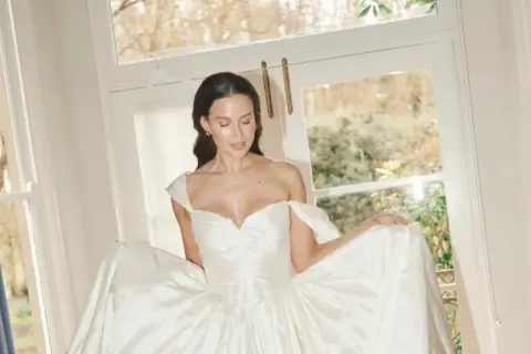 Novia radiante con un vestido de ensueño, ideal para los pelos para bodas. Luz natural y ventana al jardín.