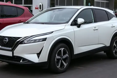 Un Nissan Qashqai blanc, parfait pour la ville, avec des jantes modernes. Ses dimensions sont idéales pour le stationnement.