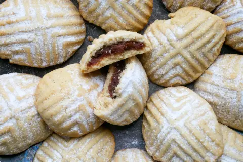 Maamoul Kekse, mit Puderzucker bestäubt, zeigen ihr köstliches Dattelfüllungs-Maamoul-Rezept.