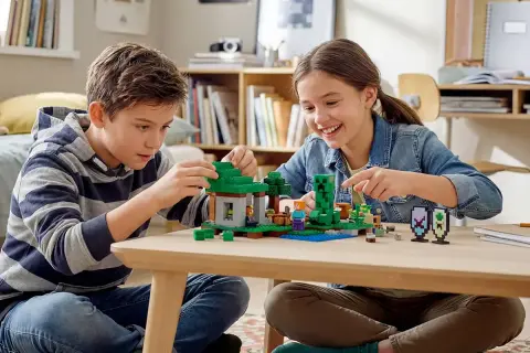Dzieci budują z klocków Minecraft, tworząc jedną z najlepszych gier LEGO. Radość i kreatywność na twarzach maluchów.