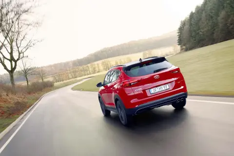 Czerwony Hyundai Tucson na zakręcie drogi. Zastanawiasz się, jaki silnik wybrać do swojego Tucsona?