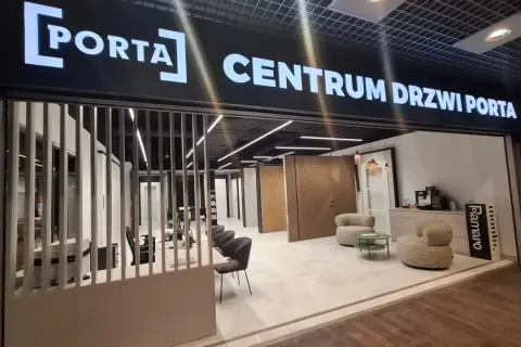 Salon drzwi i okien PORTA z ekspozycją drzwi, meblami i ekspressem do kawy.