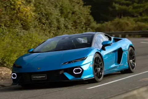Niebieskie Lamborghini Temerario pędzi po krętej drodze. Zastanawiasz się, ile kosztuje Lamborghini?