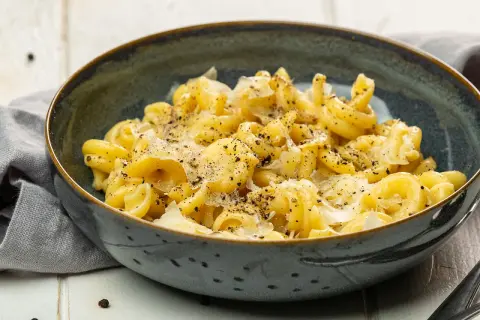 Cacio e pepe: eine Schüssel mit cremiger Pasta, bestreut mit frisch geriebenem Pecorino Romano und schwarzem Pfeffer.