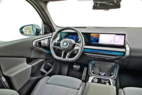 Wnętrze nowoczesnego x3 bmw z dużym ekranem nawigacji i cyfrowymi zegarami.