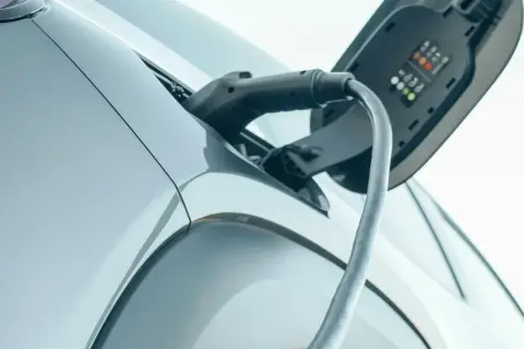 Ladda elbilen hemma då blir det dyrt. Laddkabeln ansluten till en elbil, med laddningsindikatorer synliga.
