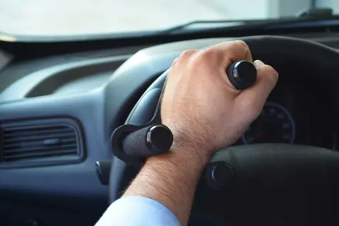 Mano con ausilio per sterzare, facilitando i comandi auto per chi ha difficoltà di presa.
