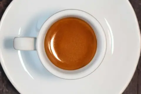 Tazzina di caffè espresso con crema dorata, risultato di un'accurata lavorazione del caffè.