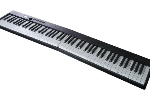 Czarny, przenośny keyboard z białymi i czarnymi klawiszami. Idealny do nauki gry na pianinie.