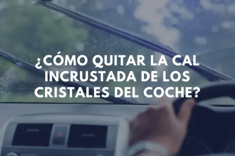 ¿Cómo quitar la cal incrustada de los cristales del coche? Imagen muestra el interior de un coche con limpiaparabrisas en acción.