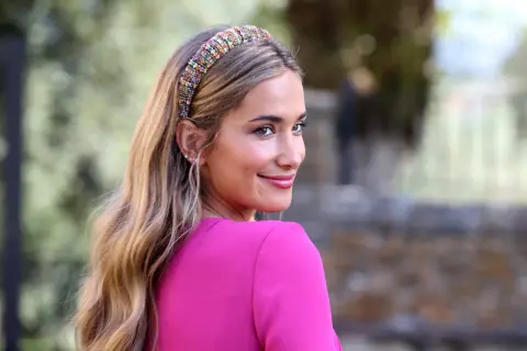 Mujer con ondas sueltas y diadema brillante, ideal para peinados de lado para boda.