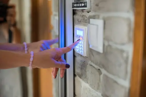 Main tenant active le système d'alarme de sa maison, espérant éviter un cambriolage.