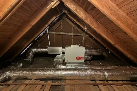 FTX-installation i en vind med isolerade ventilationsrör och en vit enhet märkt "CASA Smart".