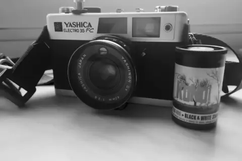 Stary aparat Yashica Electro 35 FC z obiektywem i rolką filmu czarno-białego "KONO!" 400. Klasyczny negatyw.