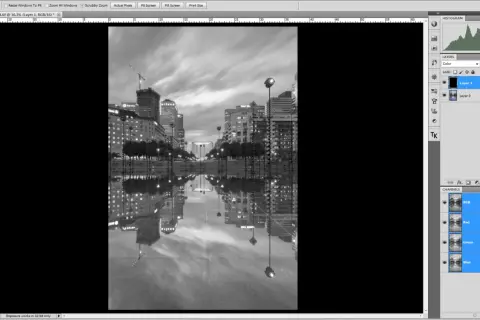 Interface Photoshop : une image de ville en noir et blanc avec ses reflets dans l'eau. Le calque "Layer 1" est sélectionné, prêt à mettre un calque en noir et blanc.
