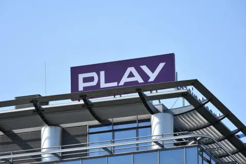 Logo PLAY na dachu budynku. Zastanawiasz się, co to roaming krajowy? To usługa, która pozwala korzystać z sieci innego operatora w Polsce.