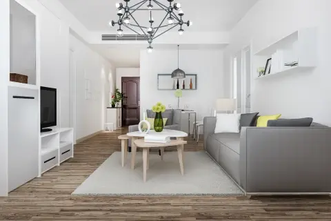 Nowoczesny salon z szarą kanapą i stolikami kawowymi. Idealne miejsce na pkd wynajem krótkoterminowy.