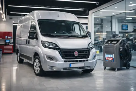 Srebrny Fiat Ducato 2.3 gotowy do serwisu. Obok maszyna do wymiany oleju Liqui Moly.
