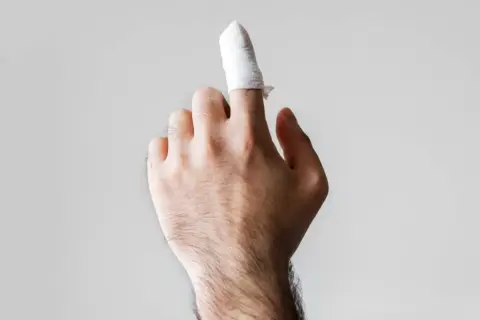 Dito con benda, forse un dito amputato dopo un incidente.