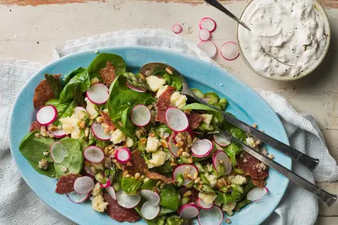 En härlig italiensk sallad med sparris, rädisor, salami och pinjenötter, serverad med en krämig dressing.