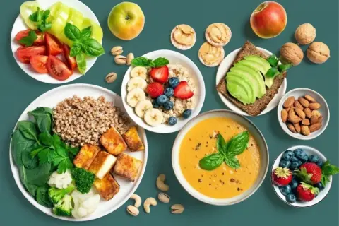 Gesunde Mahlzeiten mit proteinreichen Lebensmitteln zum Abnehmen: Buchweizen, Tofu, Gemüse, Beeren, Nüsse und Avocado.