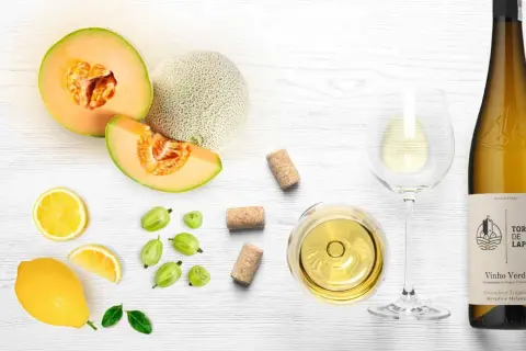 Letnia kompozycja z melonem, cytryną, agrestem i kieliszkiem orzeźwiającego **vinho verde**.